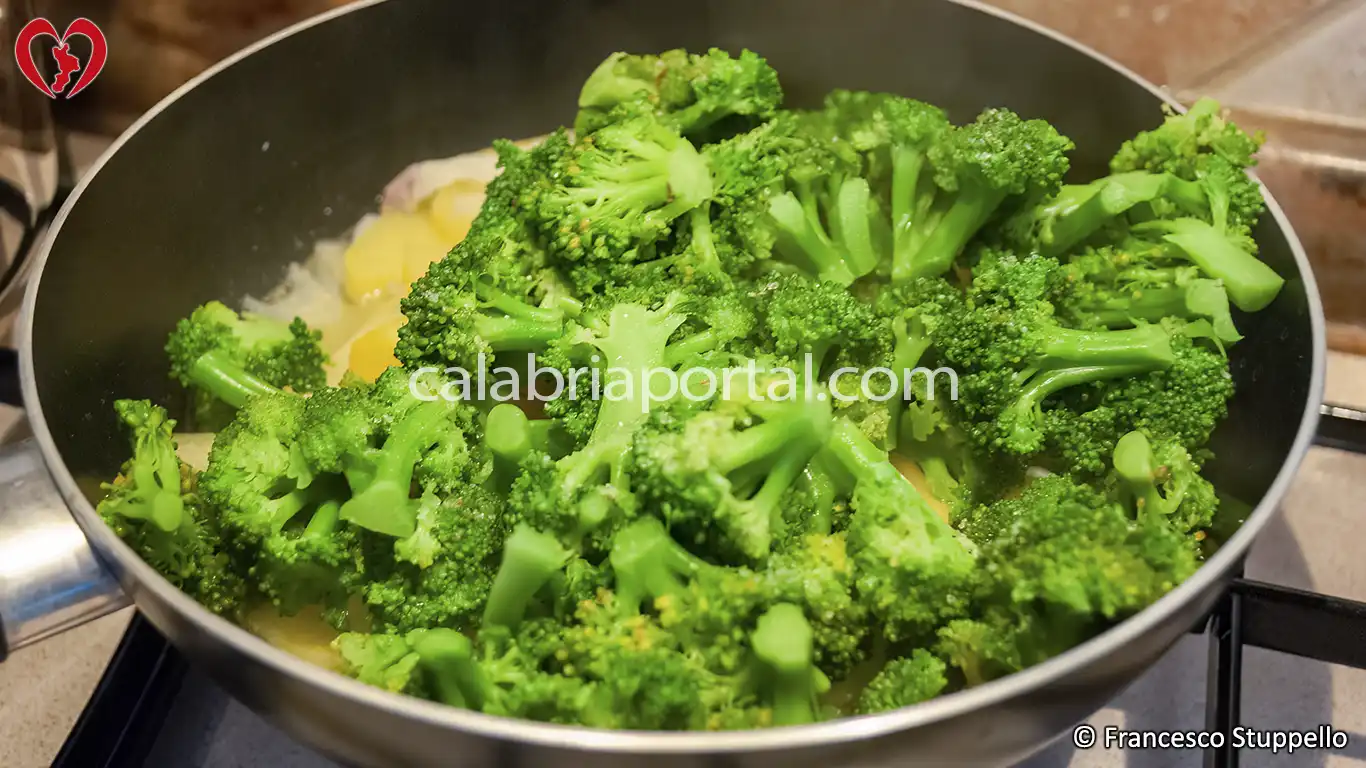Ricetta dei Broccoli e Patate Fritte alla Calabrese: aggiungete i broccoli lessati.