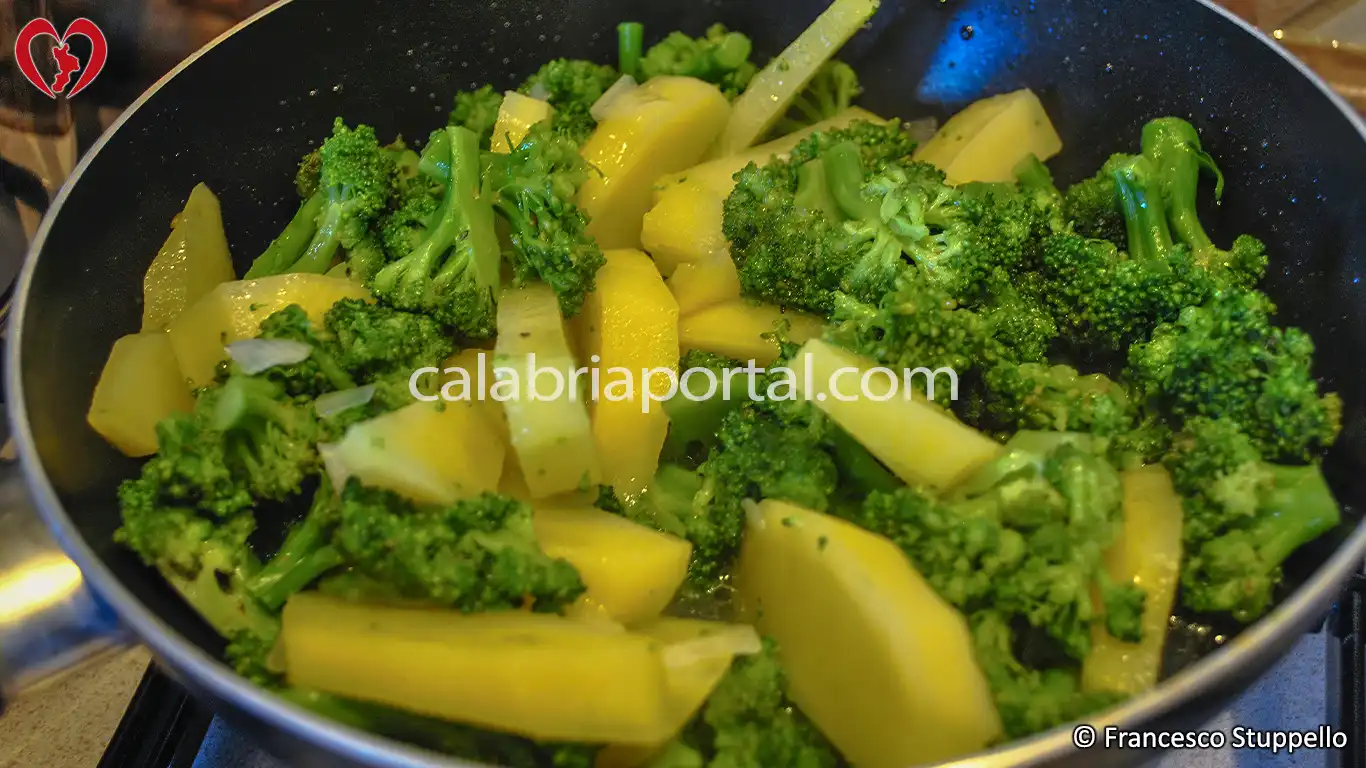 Ricetta dei Broccoli e Patate Fritte alla Calabrese: fate saltare a fuoco vivace.