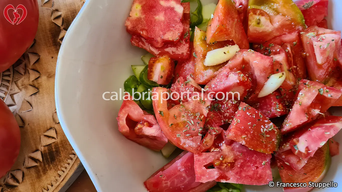 Ricetta dell'Insalata di Pomodori, Cetrioli e Peperoni alla Calabrese: tagliate a pezzi i pomodori.