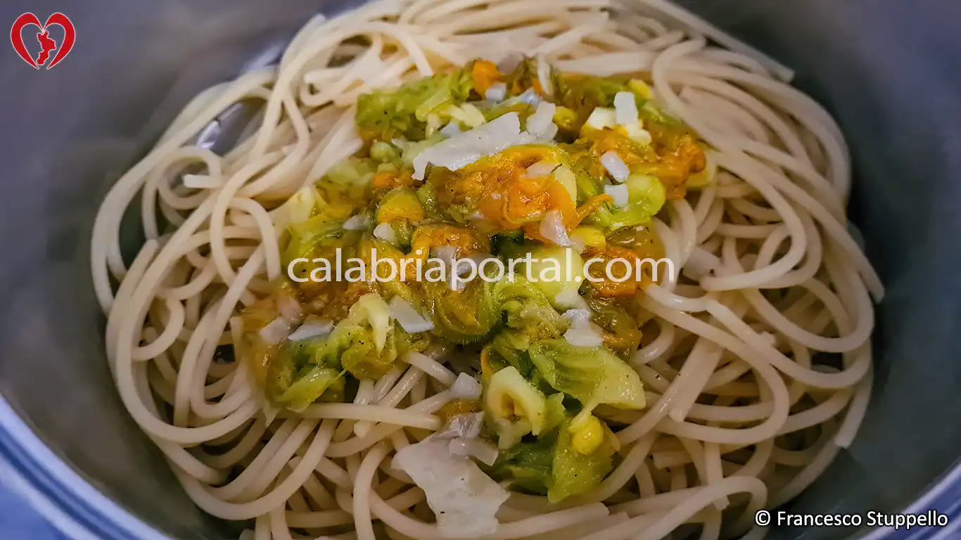 Ricetta degli Spaghetti con i Fiori di Zucca alla Calabrese: versate i fiori nella pasta e amalgamate gli ingredienti