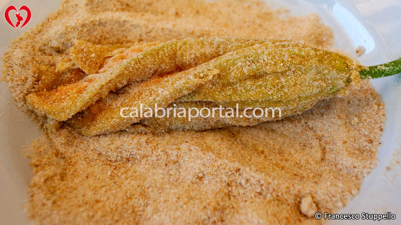 Ricetta dei Fiori di Zucca Ripieni alla Calabrese: passate il fiore nel pan grattato