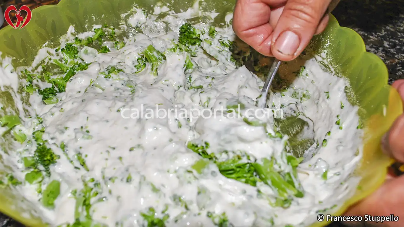 Ricetta delle Frittelle di Broccoli alla Calabrese: unite le cimette alla pastella.