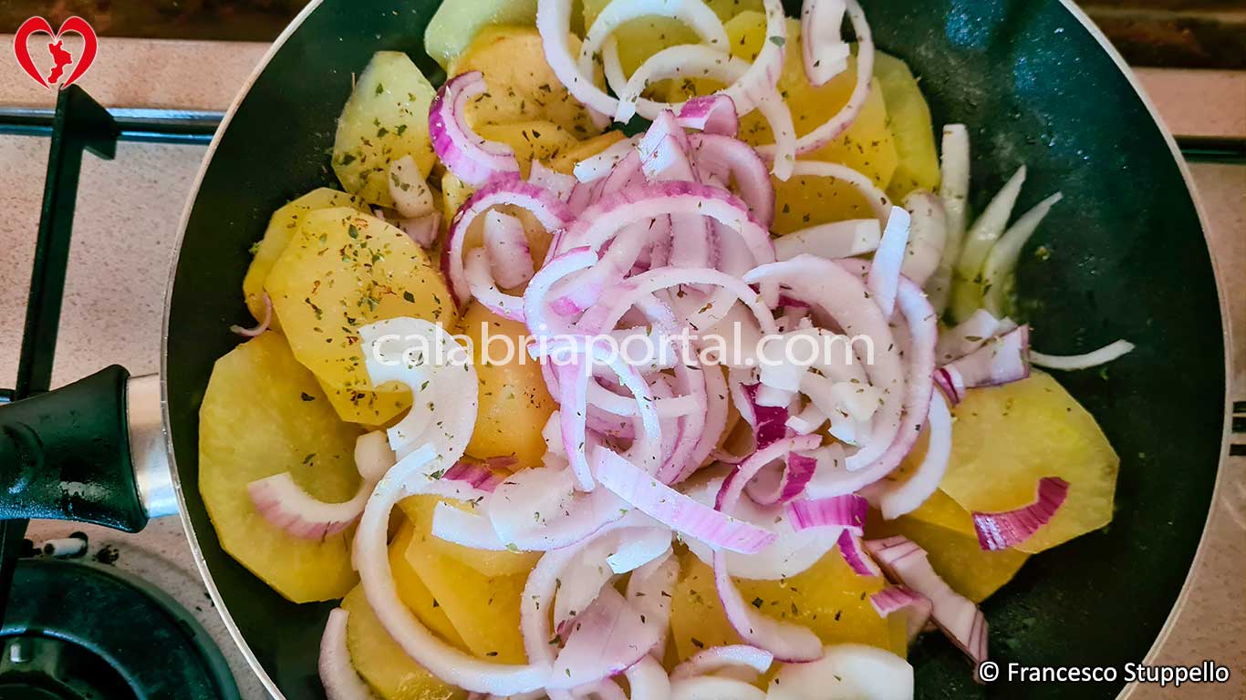 Ricetta delle Patate Mbacchiuse: a mezza cottura versate la cipolla e l'origano Ricetta delle Patate Mbacchiuse: a mezza cottura versate la cipolla e l'origano