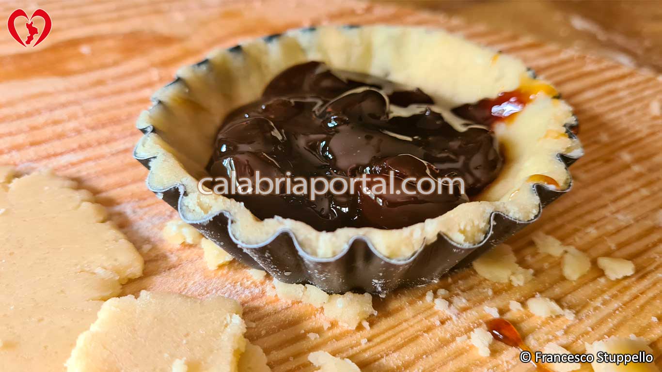 Ricetta dei Bocconotti di Mormanno: Versate la confettura di ciliegie o albicocche
