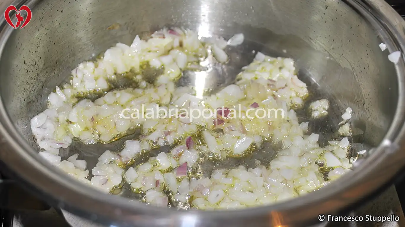 Ricetta delle Linguine con Fiori e Zucchine alla Calabrese: fate appassire la cipolla.