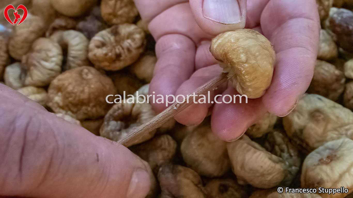 Infilzare il fico nella parte posteriore per preparare la corolla di fichi secchi Infilzare il fico nella parte posteriore per preparare la corolla di fichi secchi