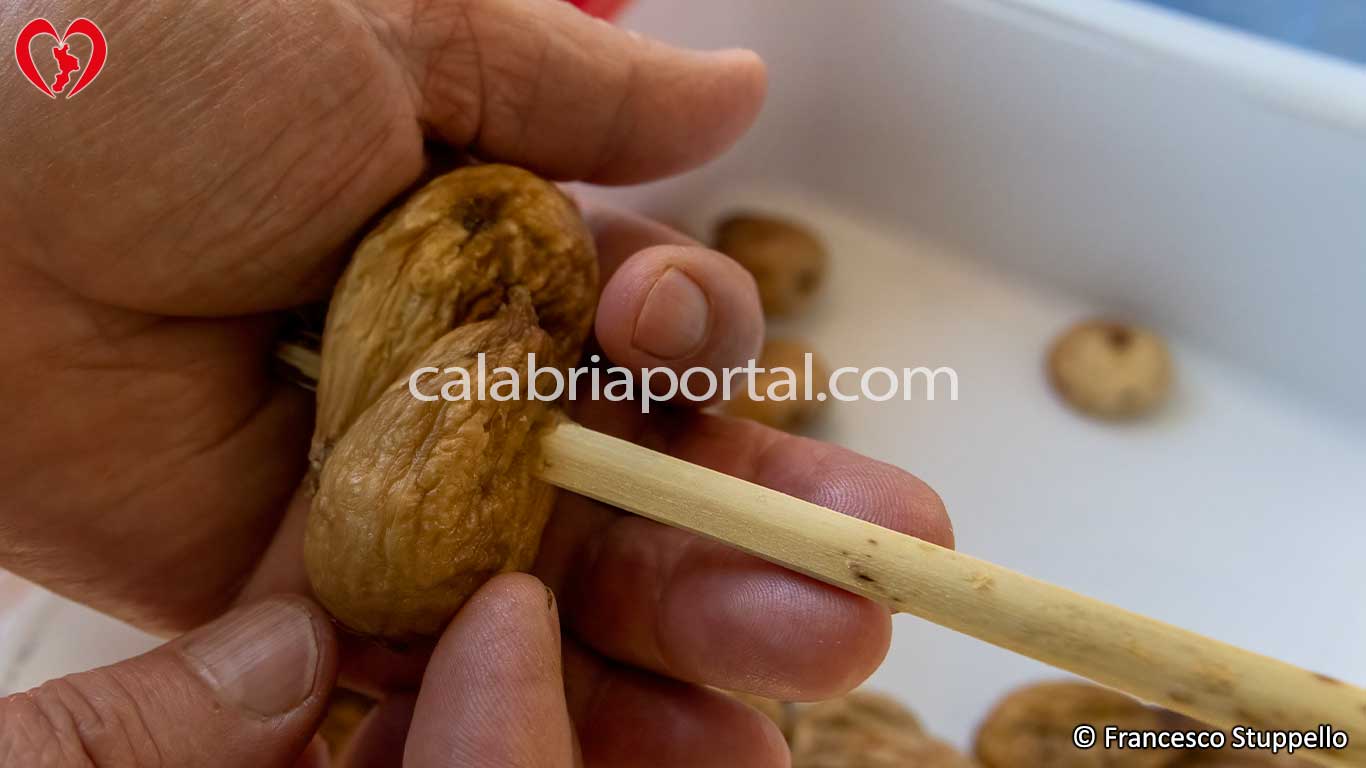 Ricetta per i Fichi Secchi a Treccia: Infilzare il secondo fico Ricetta per i Fichi Secchi a Treccia: Infilzare il secondo fico